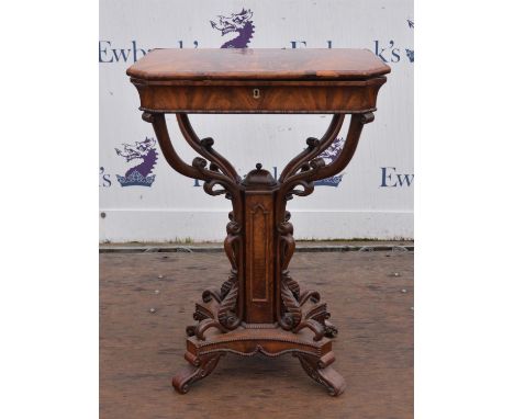 A framed mahogany work table, lift top flap opening to reveal needlework compartment raised on carved supports with single pe