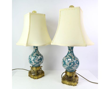 Pair of Chinese enamel and gilt metal lamps, early 20th Century, the bodies of vase form with white flowers on blue grounds, 