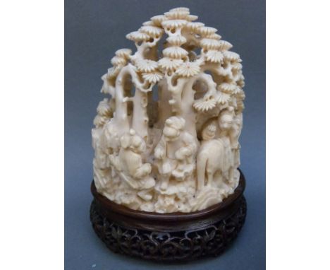 A 19thC Chinese carved ivory figural group depicting figures playing board games and a horse in a wooded area, on carved hard