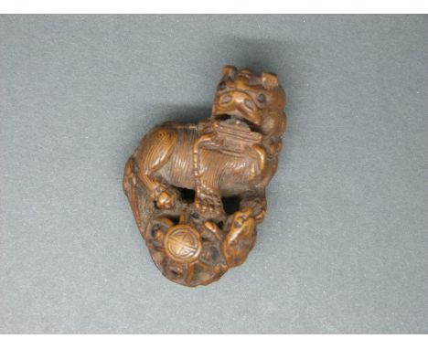 A Japanese carved wooden netsuke of a Dog of Fo, probably Meiji period
