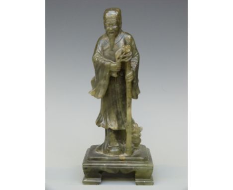 A Chinese carved spinach jade/jadeite figure of an elderly gentleman holding flowers, 21cm tall 