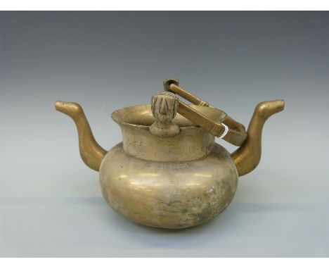 A bronze or brass twin handled pouring kettle probably Benin, 29cm tall