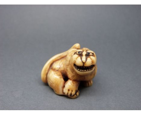 A Japanese Meiji period carved ivory netsuke of a tiger, 3cm tall