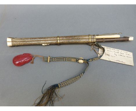 A Chinese eating set in shagreen sheath comprising knife, chopsticks and a further tool, with attached red glass netsuke with