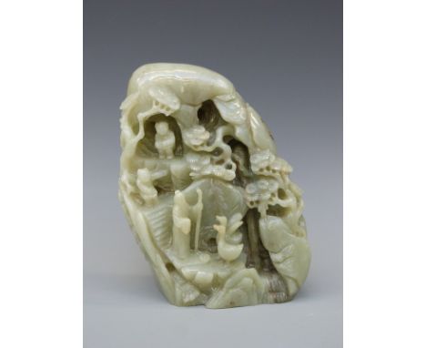 A Chinese carved bowenite jade boulder decorated with figures and animals in a naturalistic setting, signed in gilt to the to