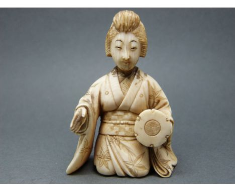 A Japanese Meiji period ivory okimono of a lady playing a drum, 5.7cm tall