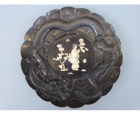A Japanese Meiji period charger with bone and mother of pearl Shibayama figural decoration in dragon surround, 25cm diameter