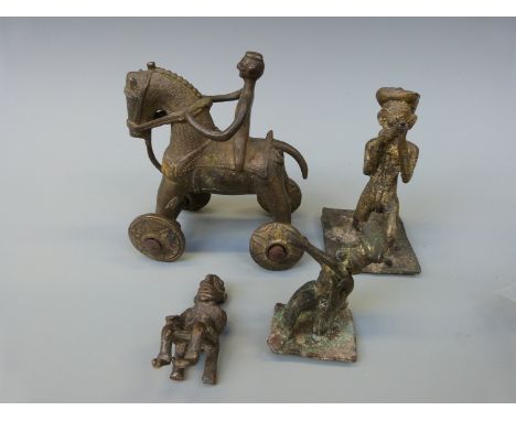 Four Ashanti brass figures including a wheeled horse and rider, a figure playing an instrument, one firing a gun and another 