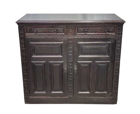 A Continental carved oak buffet. 19th century, fitted with two drawers, above two panel doors within carved stiles, height 11