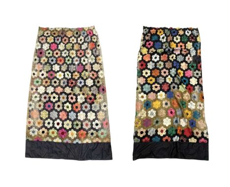 A pair of patchwork curtains. Black and green silk interspersed with a hexagonal flower design, in various fabrics including 