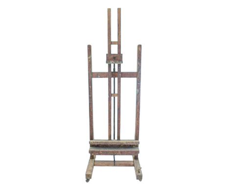A robust oak artist's easel. Early 20th century, labelled for John B Smith, Hampstead Road, London, with a cranked mechanism 