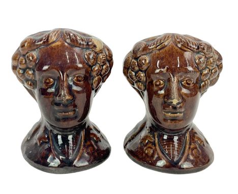 A pair of early Victorian treacle glaze sash window stops. Of bust form, height 11cm.