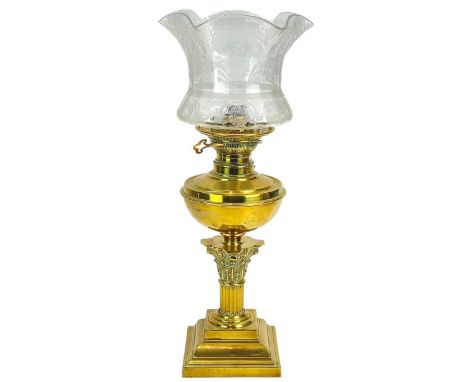 A late Victorian brass oil lamp. With a clear etched glass shade, on a Corinthian column support, overall height 52cm.There i