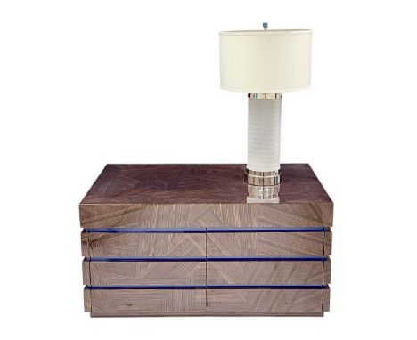 Superyacht furnishings, a contemporary low cupboard unit with an integral lamp.  A dark wood abstract patterned veneer with a