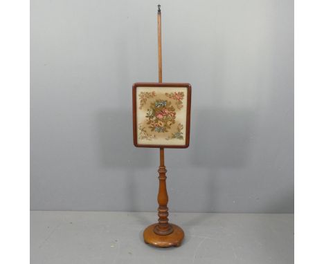 An antique mahogany and tapestry upholstered pole-screen. Height 145cm.