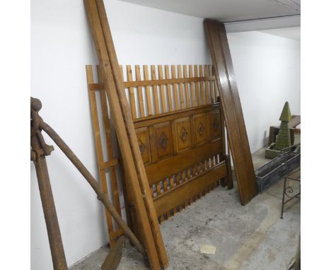 A reproduction oak King size 5ft bed, comprising panelled headboard with Tudor rose decoration, two side panels, two internal