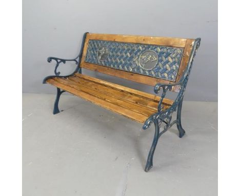 A pine slatted garden bench, with inset painted cast iron panel depicting hummingbirds and woven design, and painted cast iro