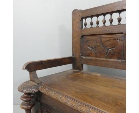 A Breton French panelled oak hall bench, with lifting seat and carved decoration. W127, 90, 50cm.