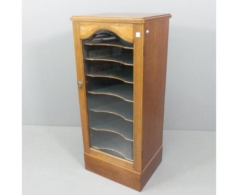 An early 20th century cross-banded mahogany and satinwood strung music cabinet, with single glazed door and shelf fitted inte