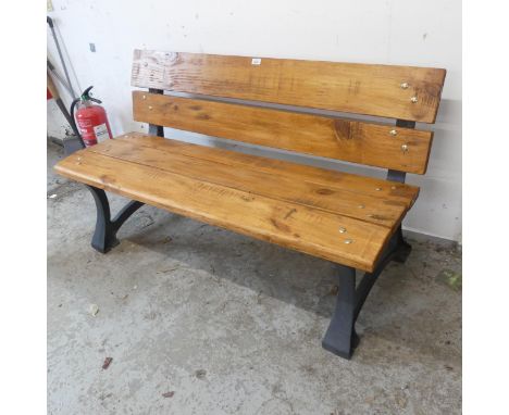 A pine garden bench on cast iron frame. Length 138cm, height 77cm, depth 60cm.