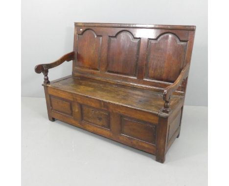 A panelled oak hall bench, with lifting seat and stile legs. Overall width 135cm, height 106cm, depth 65cm.