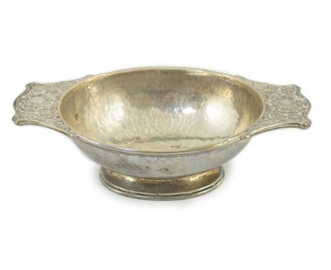 A George V Arts & Crafts planished silver two handled oval bowl by Omar Ramsden, with embossed Celtic rose decoration, 20.1cm
