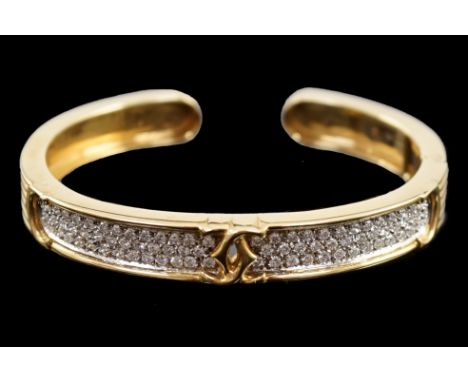 A modern 18k gold and pave set diamond Cartier open work hinged bangle, with central crossed C's motif, interior diameter 55m