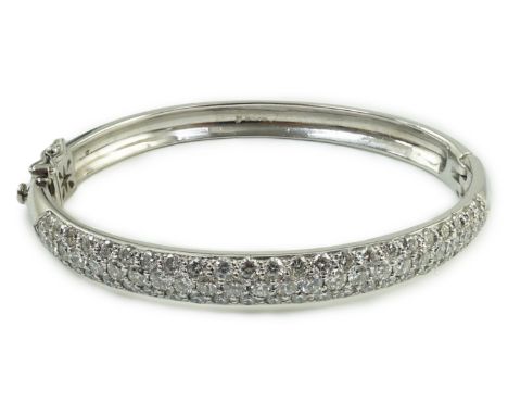 A modern 18ct white gold and pave set diamond hinged bangle, hallmarked for London, 2005, interior diameter 56mm, gross weigh