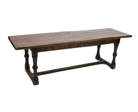 A Charles I oak refectory table, c.1630, the triple plank top with cleated ends, the four unusual two part octagonal baluster