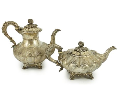 A George IV silver melon shaped coffee pot and matching tea pot by The Barnards, with thistle leaf finials and leaf and flowe