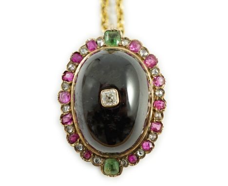 A gold, cabochon garnet, emerald, ruby and diamond cluster set oval pendant, 33mm, on a gilt chain stamped '10', 36cm, gross 