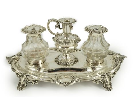 An ornate Victorian silver oval inkstand, by Henry Wilkinson &amp; Co, with foliate scroll border, two mounted glass wells an
