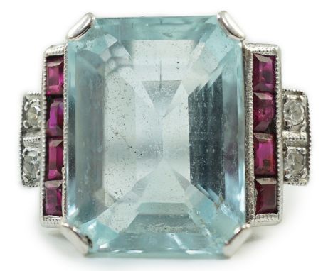 A platinum and single stone emerald cut aquamarine set dress ring, with ruby and diamond set stepped shoulders, size N, gross