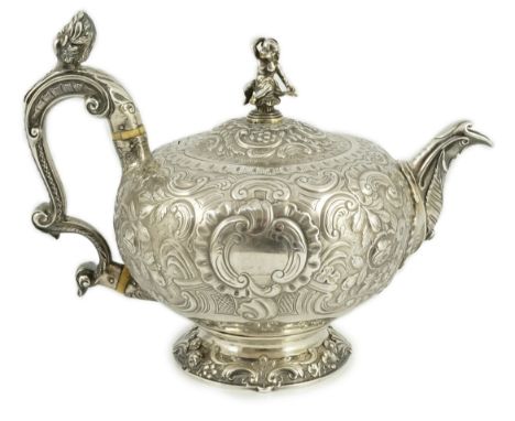 A George III silver rococo style inverted pear shaped pedestal teapot by Robert Garrard I, embossed with foliate scroll decor