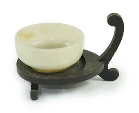 A Chinese pale celadon jade cup, Qing dynasty, of plain circular form, on a raised circular foot, the stone with white and ru