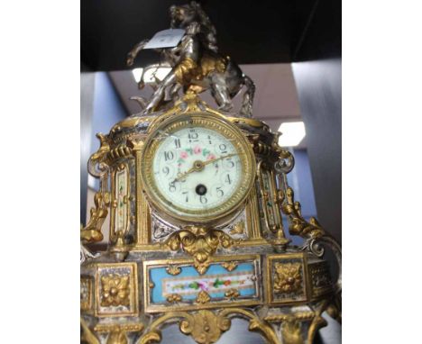 FRENCH 19TH CENTURY STYLE BRASS MANTLE CLOCK
with relief of a man and a horse, silvered and gilt, enamel dial and floral cera