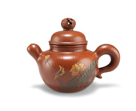 A CHINESE YIXING TEAPOT, with pierced bun-shaped finial and squat spout, decorated in low relief with a bird perched upon fol