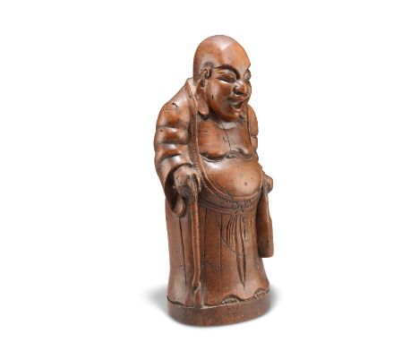 A CHINESE HARDWOOD FIGURE, QING DYNASTY, carved as an elder, holding a stick in his right hand and a satchel in his left. 29c