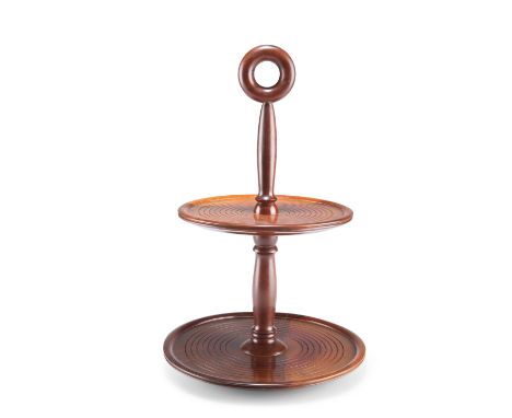 A LIGNUM VITAE TWO-TIER CAKESTAND, EARLY 20TH CENTURY, each circular "dish" with ring-turning, simple loop handle. 31cm high