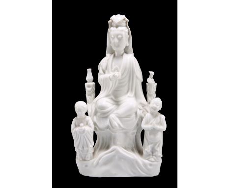 A CHINESE BLANC DE CHINE MODEL OF A GUANYIN, PROBABLY KANGXI PERIOD, modelled with attendants and holding a scroll in her rig