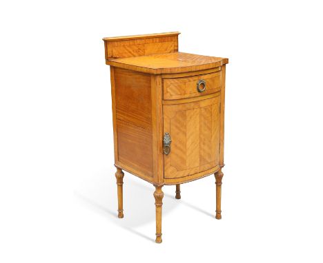 A SATINWOOD POT CUPBOARD, bow-fronted, the crossbanded and half-veneered top with conforming backboard, fitted with a short d