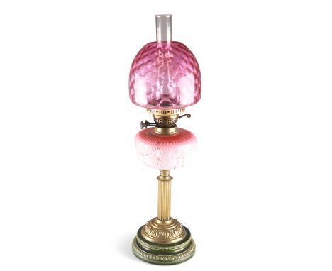 A VICTORIAN POTTERY AND BRASS OIL LAMP, with reeded columnar stem and moulded cased glass reservoir below a cranberry glass s