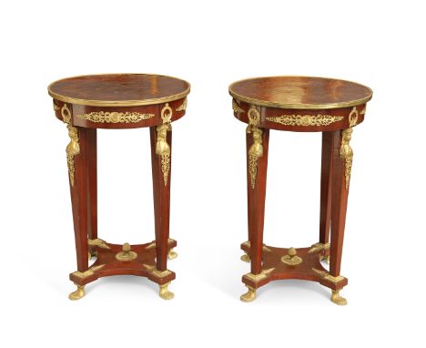 A PAIR OF EMPIRE STYLE BRASS-MOUNTED MAHOGANY GUÉRIDONS, of characteristic form with circular tops, the friezes applied with 
