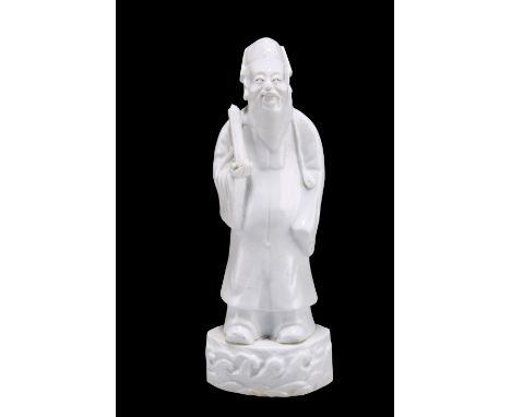 A CHINESE BLANC DE CHINE FIGURE OF A SCHOLAR, PROBABLY KANGXI PERIOD,&nbsp;modelled standing holding a scroll in his right ha