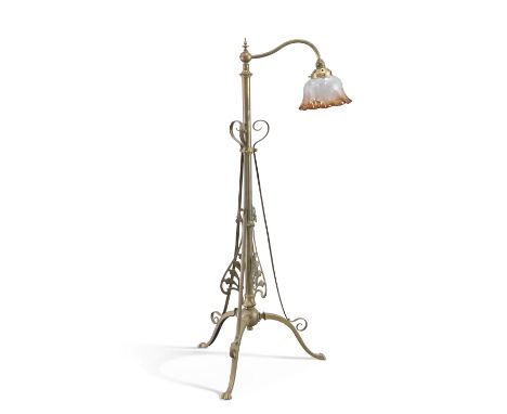 AN ART NOUVEAU BRASS TELESCOPIC STANDARD LAMP, raised on a tripod base, with floral etched tinted shade. Minimum height 122cm