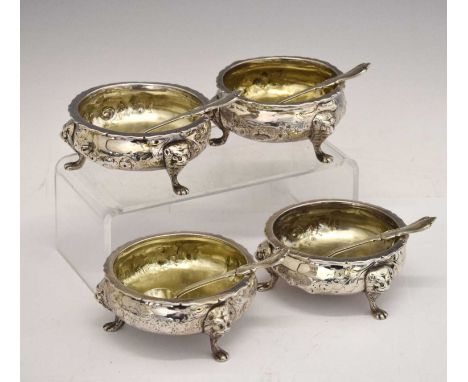 Matched set of four silver salts chased with floral decoration and each standing on three mask and paw feet: a provincial Geo