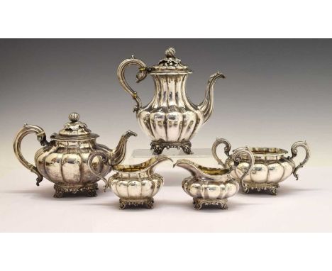 A matched 19th century silver tea and coffee service of compressed melon form with scroll handles comprising a four-piece cof