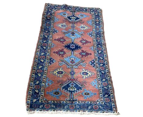 A pretty Heriz wool rug, 20th century, with a central pole medallion and florets, on a light crimson ground, within guard str