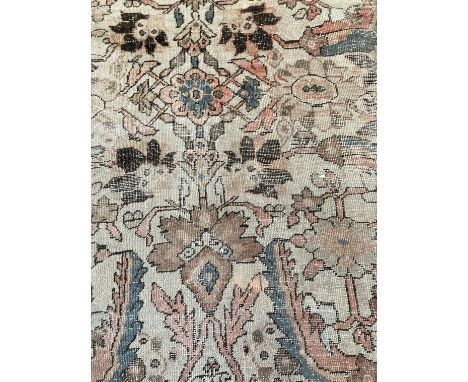 A large North West Persian Ushak carpet,   with foliate motif field within border with stylized flowerheads, well worn in pla