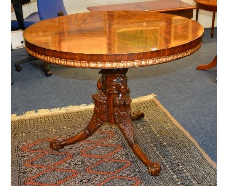 A good reproduction circular supper table, raised on carved column with masks and tripod supports, terminating with ball and 